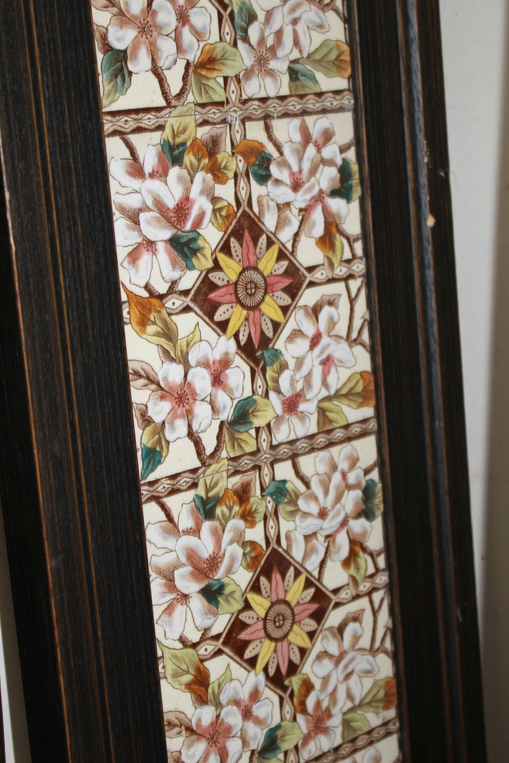 A pair of Victorian apple blossom tile panels and a set of six Art Nouveau foliate design tiles, all framed